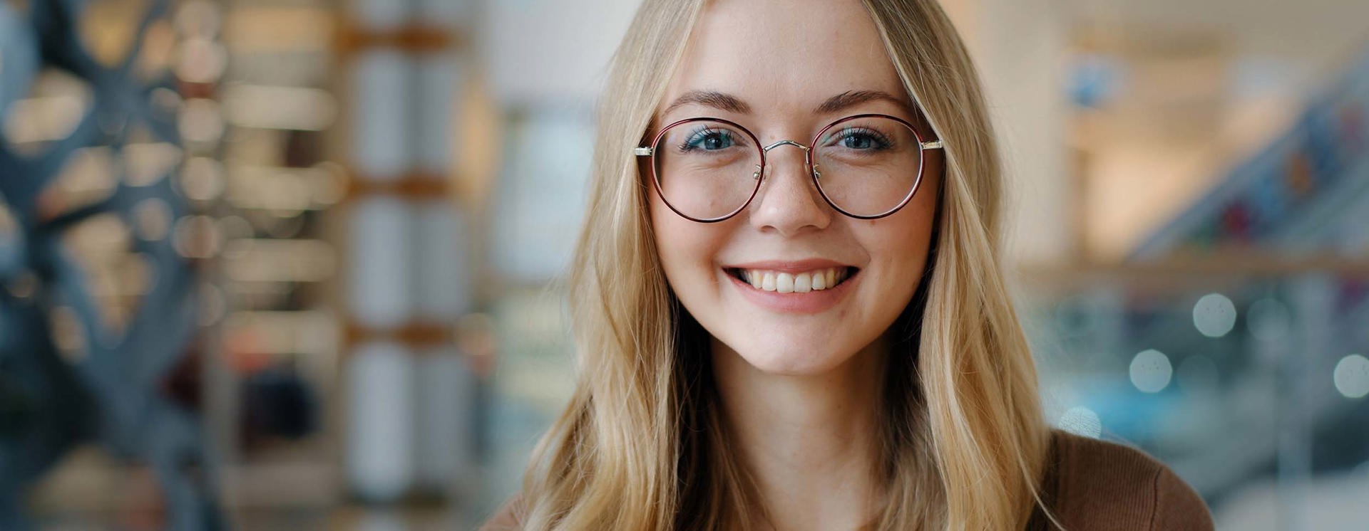Person med glasögon i modern kontors- eller industrimiljö som representerar digitalt arbetssätt och kompetens inom smart industri