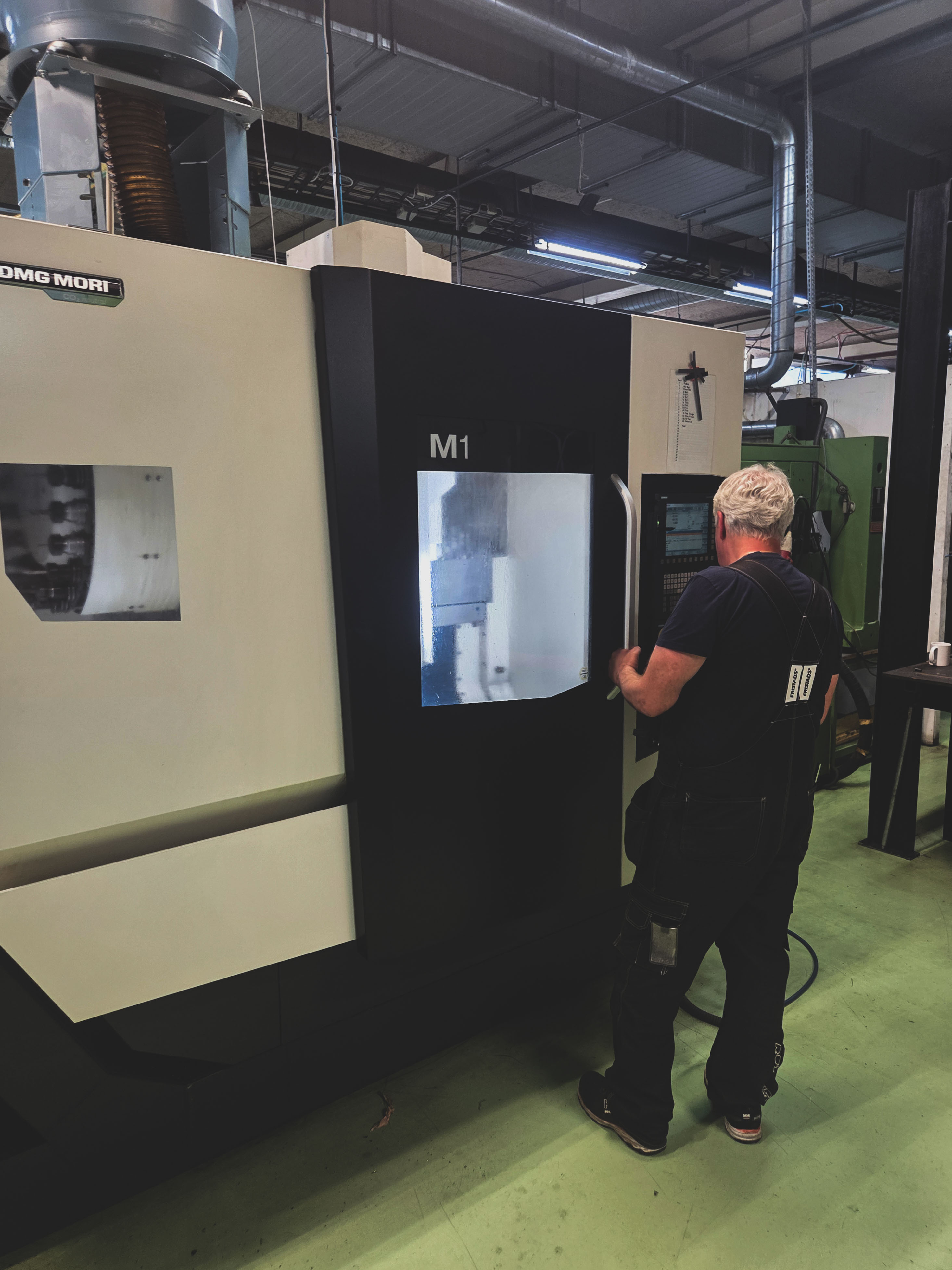 Operatör Arbetar Vid CNC Maskin I Produktionsmiljö För Bearbetning Och Tillverkning Av Metallkomponenter Med Hög
