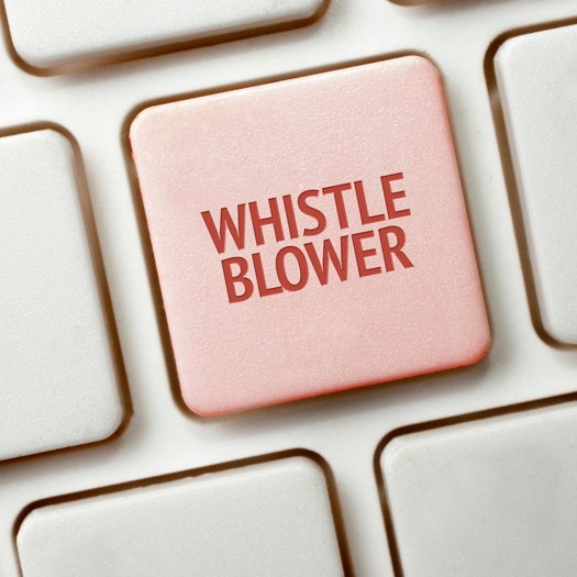 Ett inzoomat tangentbord med ordet Whistle Blower på, svenska Visselblåsare - Visselblåsning