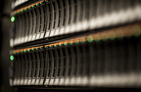 Närbild av serverrack i datacenter med blinkande LED‑lampor och lagringsenheter, vilket visar IT‑infrastruktur, serverdrift, datalagring och säker hantering av affärssystem i modern IT‑miljö