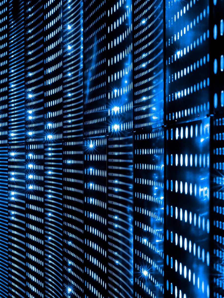 Serverhall med blå LED‑belysning och rader av serverrack som visar datacenter, colocation, högpresterande IT‑infrastruktur och säker drift av affärssystem och molntjänster