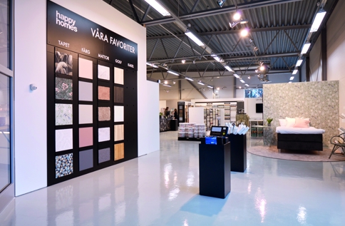 Interiör i Happy Homes-butik med inspirerande utställningar för tapeter, färg, golv, kakel och heminredning i modern butiksmiljö