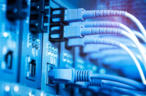 Närbild av nätverkskablar anslutna till switch i servermiljö, vilket illustrerar IT‑infrastruktur, datakommunikation, brandvägg som tjänst och säker nätverkshantering i modern IT‑miljö