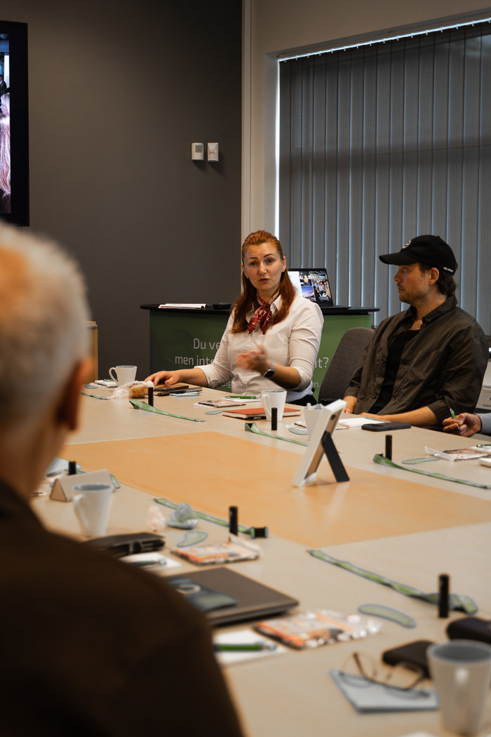 Person presenterar vid konferensbord under nätverksmöte