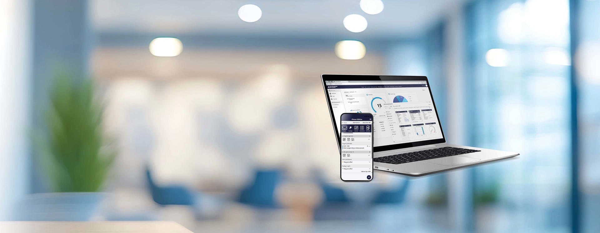Laptop och mobil som visar affärssystem med dashboards, KPI:er och dataanalys i modern arbetsmiljö, vilket illustrerar digital uppföljning och tillgänglighet i verksamheten