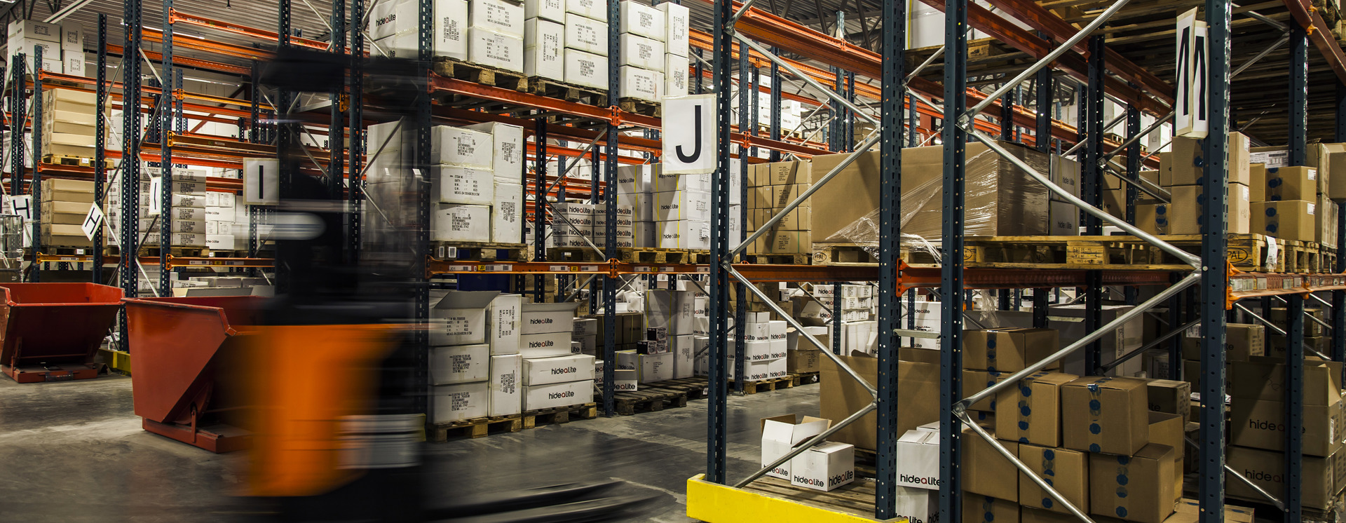 Lagerhall med höglager, trucktrafik och pallställ för effektiv lagerhantering, logistik och distribution av produkter
